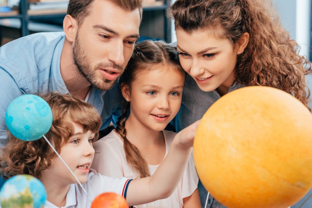 family exploring solar system model for school project